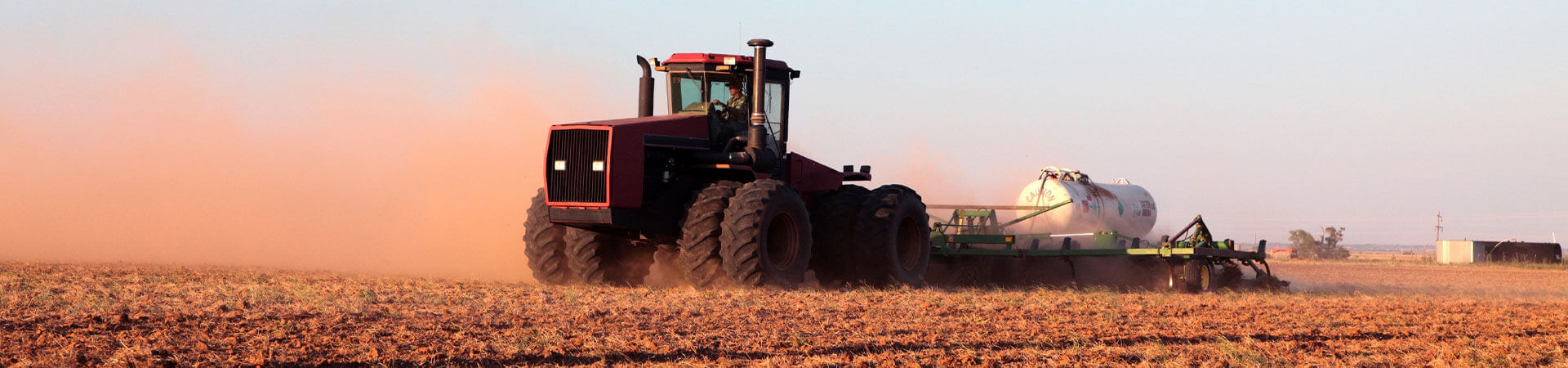 Farmer in a Tractor driving on his farm.